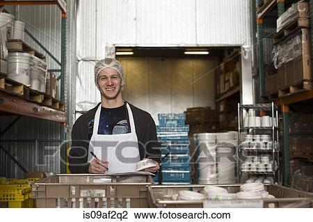 Factory worker checking products in warehouse View Large Photo Image Stock Image - Factory worker checking products in warehouse. Fotosearch