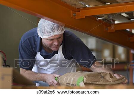 Factory worker handling parcel View Large Photo Image Stock Photograph - Factory worker handling parcel. Fotosearch