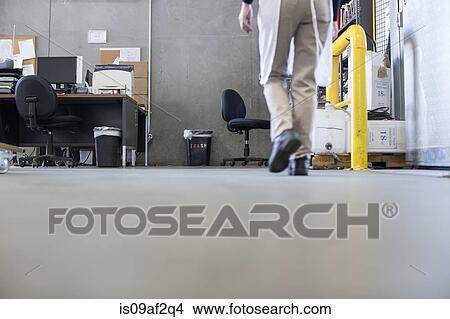 Factory worker walking along floor, low section View Large Photo Image Picture - Factory worker walking along floor, low section. Fotosearch