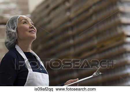 Factory worker with clipboard in warehouse View Large Photo Image Stock Photography - Factory worker with clipboard in warehouse. Fotosearch