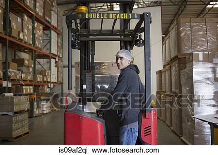 Factory worker with fork lift in warehouse View Large Photo Image Stock Image - Factory worker with fork lift in warehouse. Fotosearch
