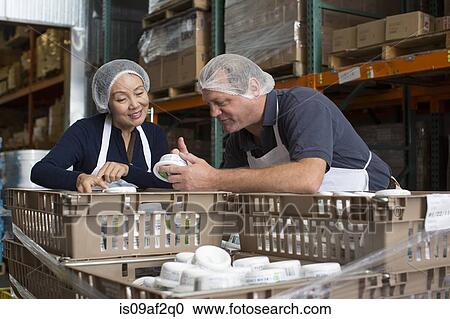 Factory workers checking products in warehouse View Large Photo Image Stock Image - Factory workers checking products in warehouse. Fotosearch