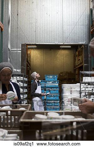 Factory workers checking products in warehouse View Large Photo Image Stock Image - Factory workers checking products in warehouse. Fotosearch
