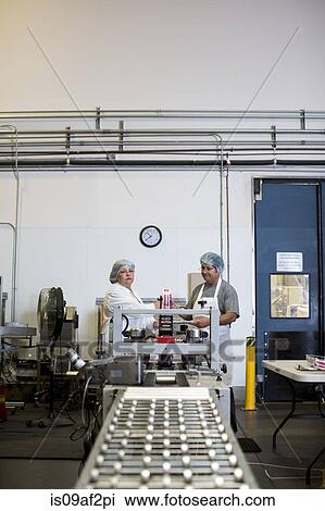Stock Image - Factory workers on production line. Fotosearch