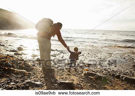 Stock Image - Father and child enjoying beach. Fotosearch