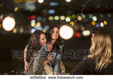 Female friends dancing at rooftop party View Large Photo Image Picture - Female friends dancing at rooftop party. Fotosearch