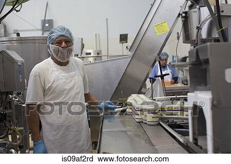 Stock Image - Man working in food production factory. Fotosearch