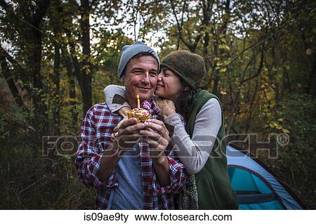 Mature couple outside tent holding birthday cupcake View Large Photo Image Stock Photo - Mature couple outside tent holding birthday cupcake. Fotosearch