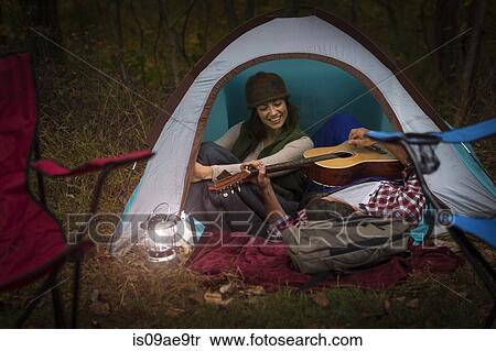 Mature couple sitting in tent, playing guitar View Large Photo Image Stock Photography - Mature couple sitting in tent, playing guitar. Fotosearch