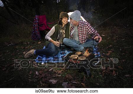 Mature couple sitting outside tent with barbecue and glass of wine View Large Photo Image Stock Photograph - Mature couple sitting outside tent with barbecue and glass of wine. Fotosearch