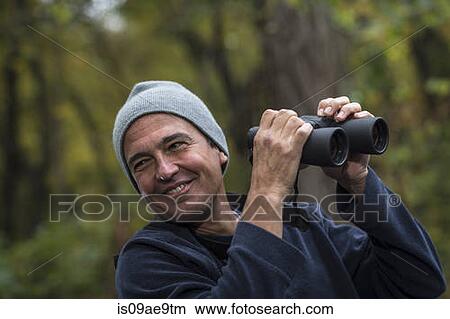 Picture - Mature man holding binoculars. Fotosearch