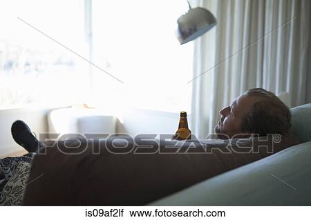 Mature man with eyes closed reclining on sofa View Large Photo Image Stock Image - Mature man with eyes closed reclining on sofa. Fotosearch