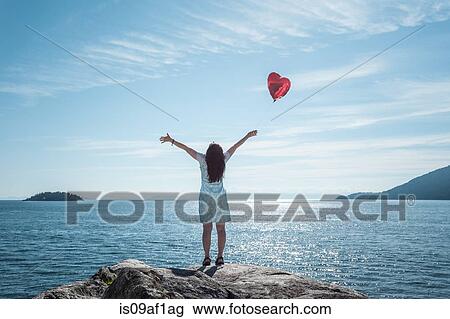 Mature woman arms outstretched with heart shaped balloon View Large Photo Image Stock Image - Mature woman arms outstretched with heart shaped balloon. Fotosearch