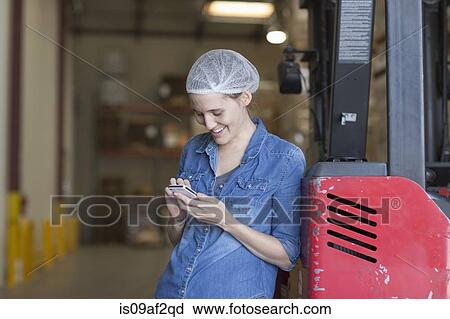 Portrait of female factory worker using cell phone View Large Photo Image Stock Image - Portrait of female factory worker using cell phone. Fotosearch