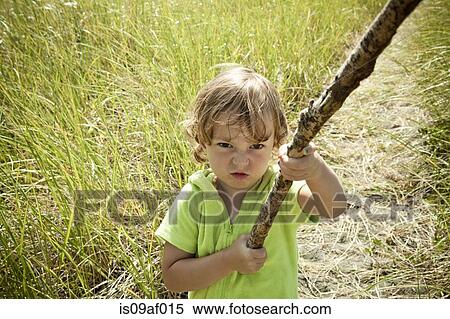Stock Photography - Portrait of female toddler holding long stick. Fotosearch