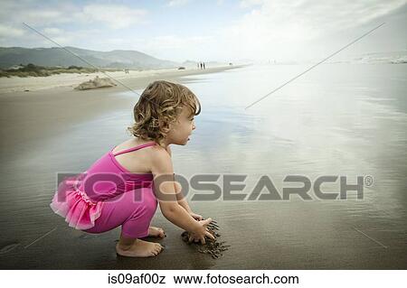 Portrait of female toddler playing in sand View Large Photo Image Stock Photo - Portrait of female toddler playing in sand. Fotosearch