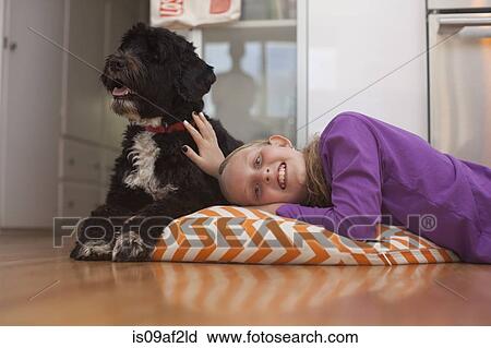 Portrait of girl lying on cushion with pet dog View Large Photo Image Stock Image - Portrait of girl lying on cushion with pet dog. Fotosearch