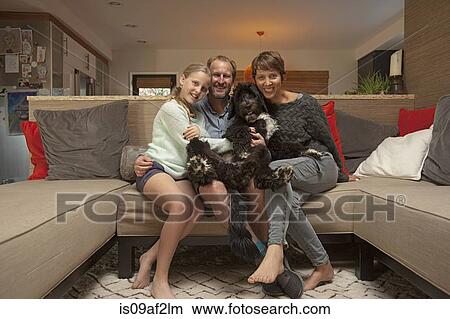 Portrait of parents, daughter and pet dog on sofa View Large Photo Image Picture - Portrait of parents, daughter and pet dog on sofa. Fotosearch