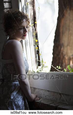 Portrait of young woman daydreaming at conservatory window View Large Photo Image Stock Photograph - Portrait of young woman daydreaming at conservatory window. Fotosearch