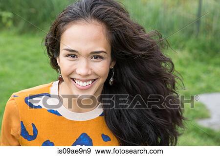 Stock Photo - Portrait of young woman in park. Fotosearch