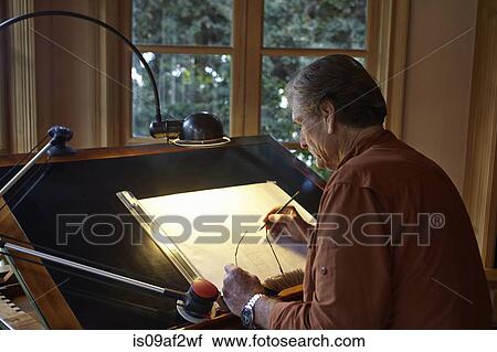 Senior man working on architectural drawing at home View Large Photo Image Stock Image - Senior man working on architectural drawing at home. Fotosearch