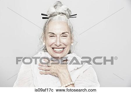 Stock Image - Studio portrait of sophisticated senior woman laughing. Fotosearch