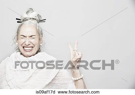 Studio portrait of sophisticated senior woman making victory sign View Large Photo Image Stock Image - Studio portrait of sophisticated senior woman making victory sign. Fotosearch