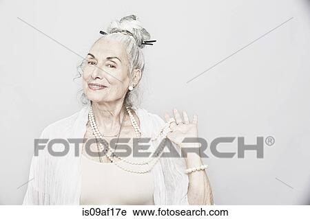 Studio portrait of sophisticated senior woman holding beads View Large Photo Image Stock Image - Studio portrait of sophisticated senior woman holding beads. Fotosearch