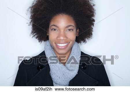 Stock Image - Studio portrait of young woman with afro. Fotosearch