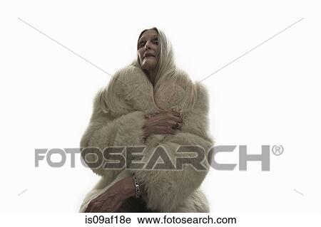Stock Image - Studio shot of mature woman looking down. Fotosearch