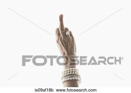 Stock Image - Studio shot of mature woman's hand making obscene gesture. Fotosearch