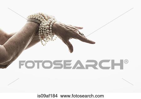 Picture - Studio shot of mature woman's hands wearing jewelry. Fotosearch