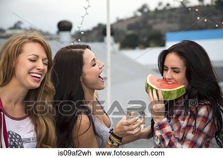 Three young women at barbeque with large slice of melon View Large Photo Image Stock Image - Three young women at barbeque with large slice of melon. Fotosearch