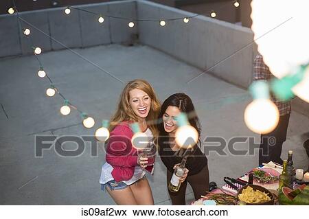 Two female friends dancing at rooftop party View Large Photo Image Stock Photo - Two female friends dancing at rooftop party. Fotosearch