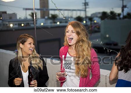 Two female friends having fun at rooftop party View Large Photo Image Stock Photo - Two female friends having fun at rooftop party. Fotosearch