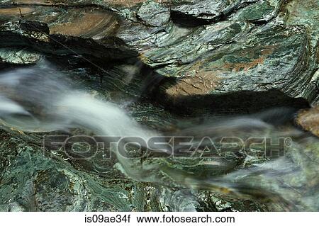 Stock Image - Water running over rocks, Glacier National Park, Montana, USA. Fotosearch