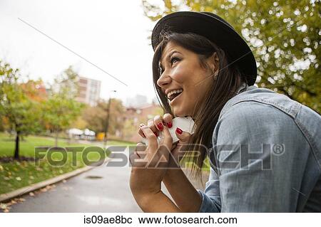 Woman holding cellular phone to chin View Large Photo Image Stock Image - Woman holding cellular phone to chin. Fotosearch