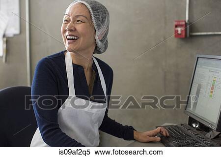 Woman wearing apron and hairnet using computer View Large Photo Image Stock Photography - Woman wearing apron and hairnet using computer. Fotosearch
