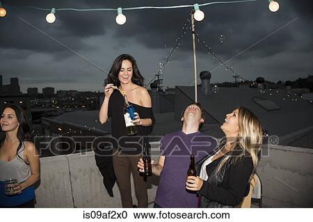 Young adult friends blowing bubbles at rooftop party View Large Photo Image Stock Image - Young adult friends blowing bubbles at rooftop party. Fotosearch