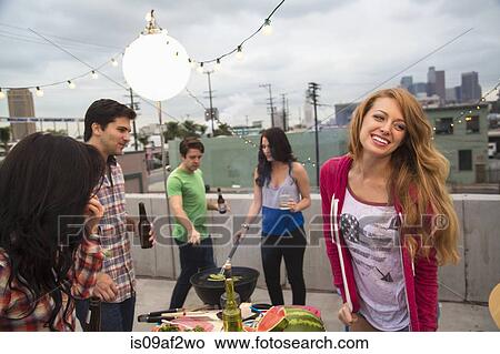 Picture - Young adult friends enjoying barbeque. Fotosearch