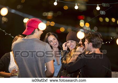 Young adult friends having fun at rooftop party View Large Photo Image Stock Image - Young adult friends having fun at rooftop party. Fotosearch