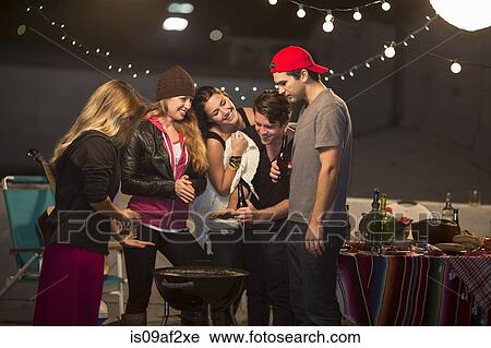 Young adult friends keeping warm at rooftop party View Large Photo Image Stock Image - Young adult friends keeping warm at rooftop party. Fotosearch