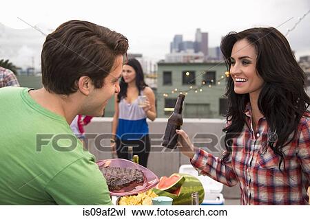 Young couple flirting at barbeque View Large Photo Image Stock Image - Young couple flirting at barbeque. Fotosearch