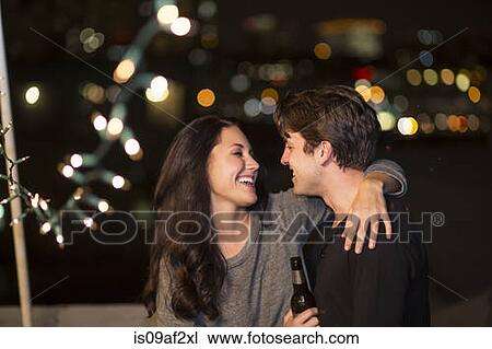 Young couple having fun at rooftop party View Large Photo Image Stock Image - Young couple having fun at rooftop party. Fotosearch