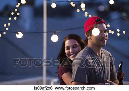 Young couple hugging at rooftop barbecue View Large Photo Image Stock Photograph - Young couple hugging at rooftop barbecue. Fotosearch