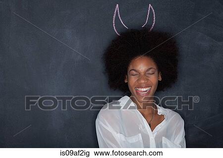 Young woman by blackboard with horns View Large Photo Image Stock Image - Young woman by blackboard with horns. Fotosearch