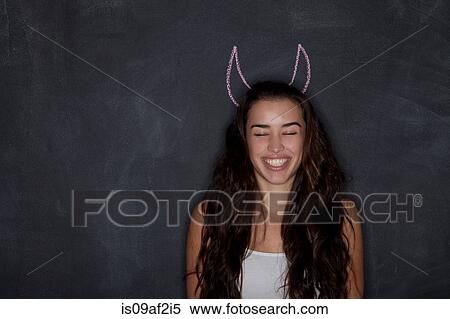 Young woman by blackboard with horns View Large Photo Image Stock Photography - Young woman by blackboard with horns. Fotosearch
