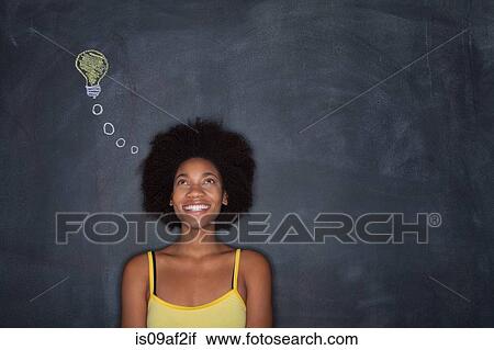 Young woman by blackboard with lightbulb View Large Photo Image Stock Image - Young woman by blackboard with lightbulb. Fotosearch