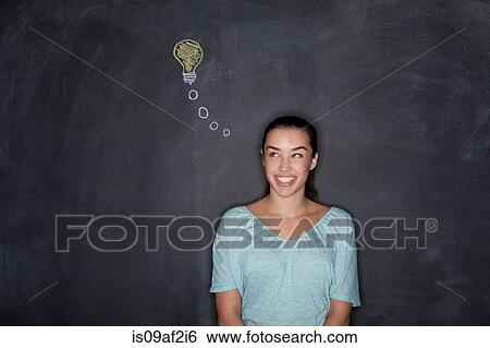 Young woman by blackboard with lightbulb View Large Photo Image Stock Photograph - Young woman by blackboard with lightbulb. Fotosearch