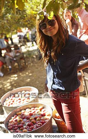Young woman standing beside barrels of apples View Large Photo Image Stock Image - Young woman standing beside barrels of apples. Fotosearch